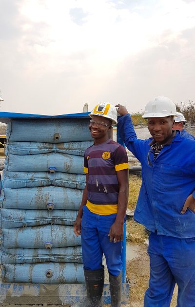 Two members of the Spirotech team on site in front of stacked support bags